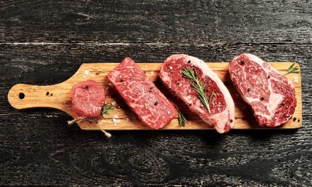 Fresh raw Prime Black Angus beef steaks on wooden board Carnes