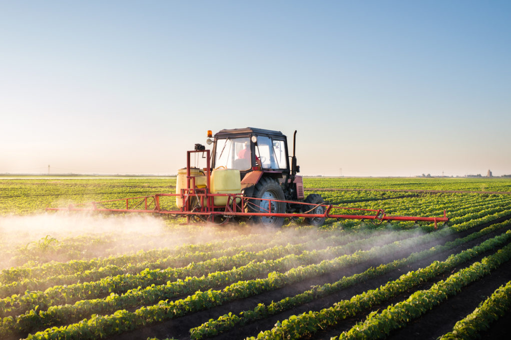 Tractor spraying soybean field