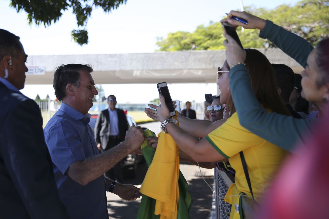 Presidente Jair Bolsonaro cumprimenta populares na saída do Alvorada