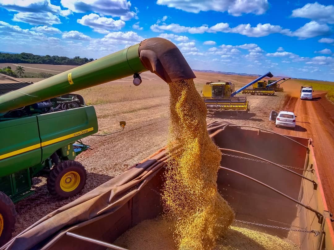 bico da colheitadeira despejando soja no caminhao