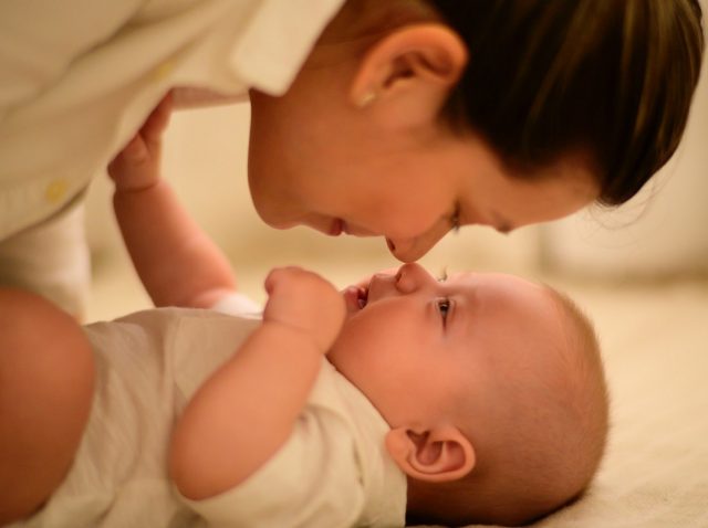 mae fazendo carinho em bebe deitado mae fazendo carinho em bebe deitado