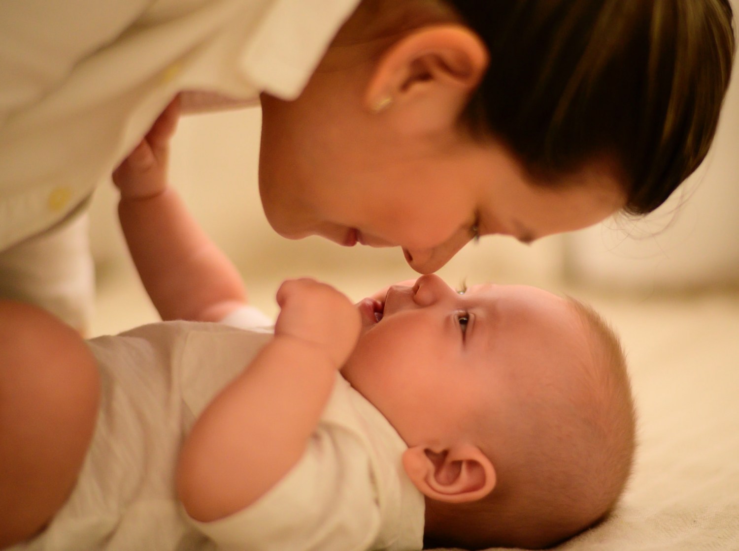 mae fazendo carinho em bebe deitado