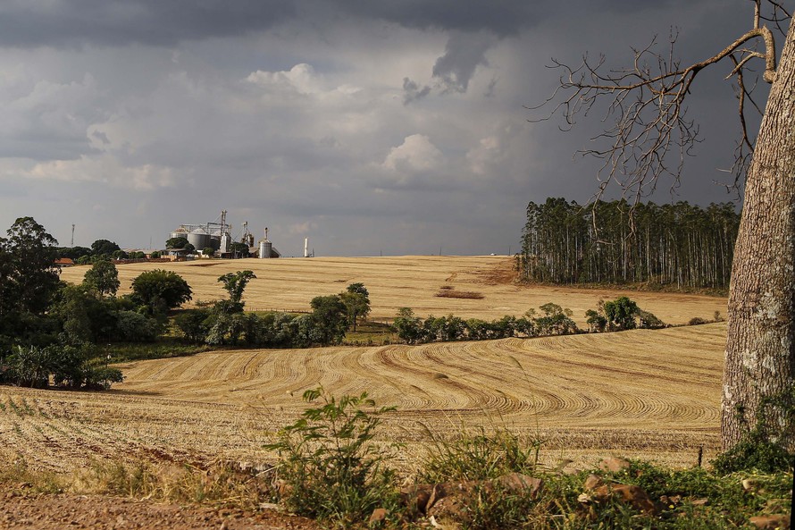 fazenda com silo ao fundo acabou de colher com previsao de chuva