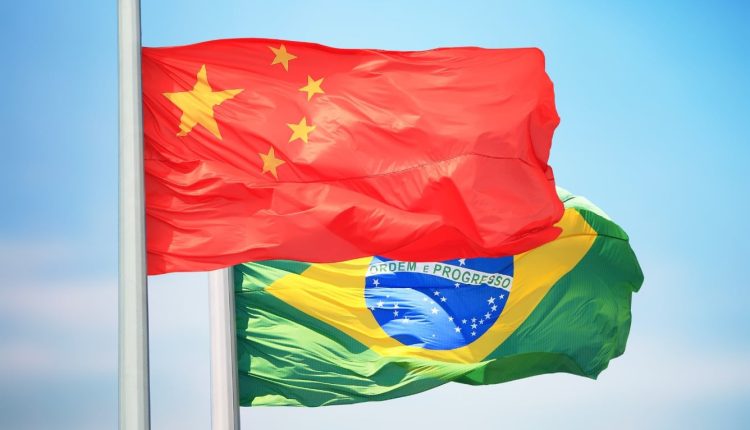 bandeira da china em primeiro plano com bandeira do brasil atras