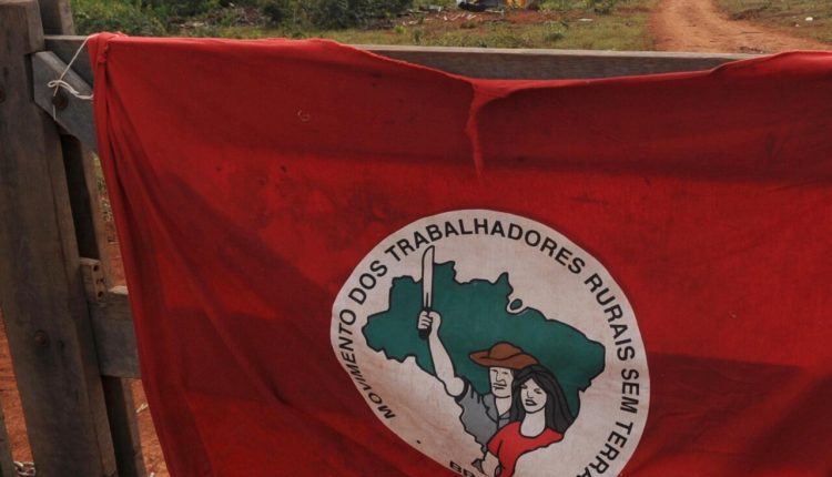 bandeira do mst pendurada na porteira da fazenda