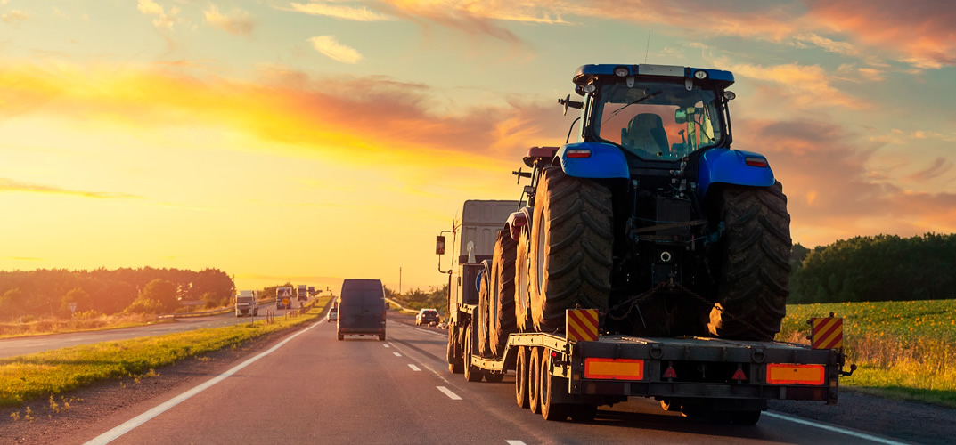 maquinas agricolas transportadas por prancha em rodovia