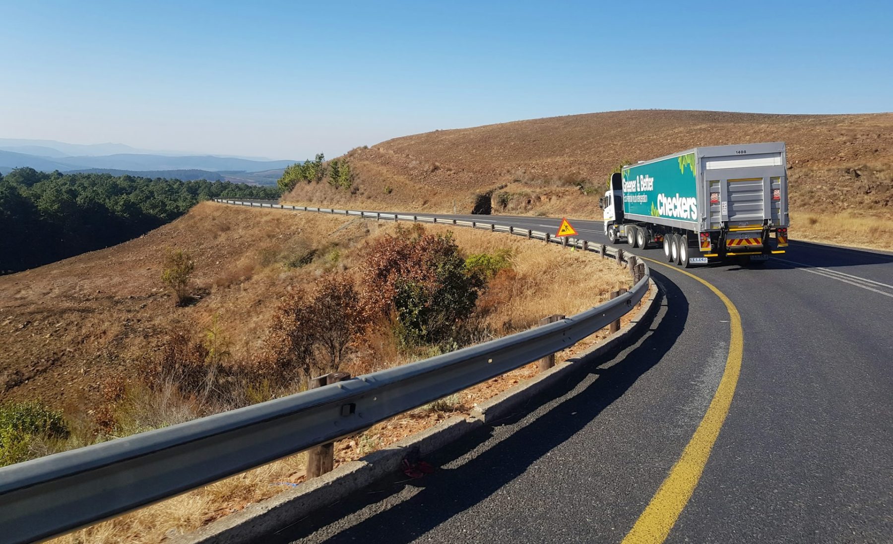 Caminhao rodando na rodovia com guardrail