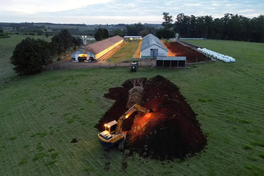 Escavadeira abre buraco em chão de granja avícola na cidade de Montenegro, no Rio Grande do Sul, após a confirmação de caso de gripe aviária. — Foto: REUTERS/Diego Vara